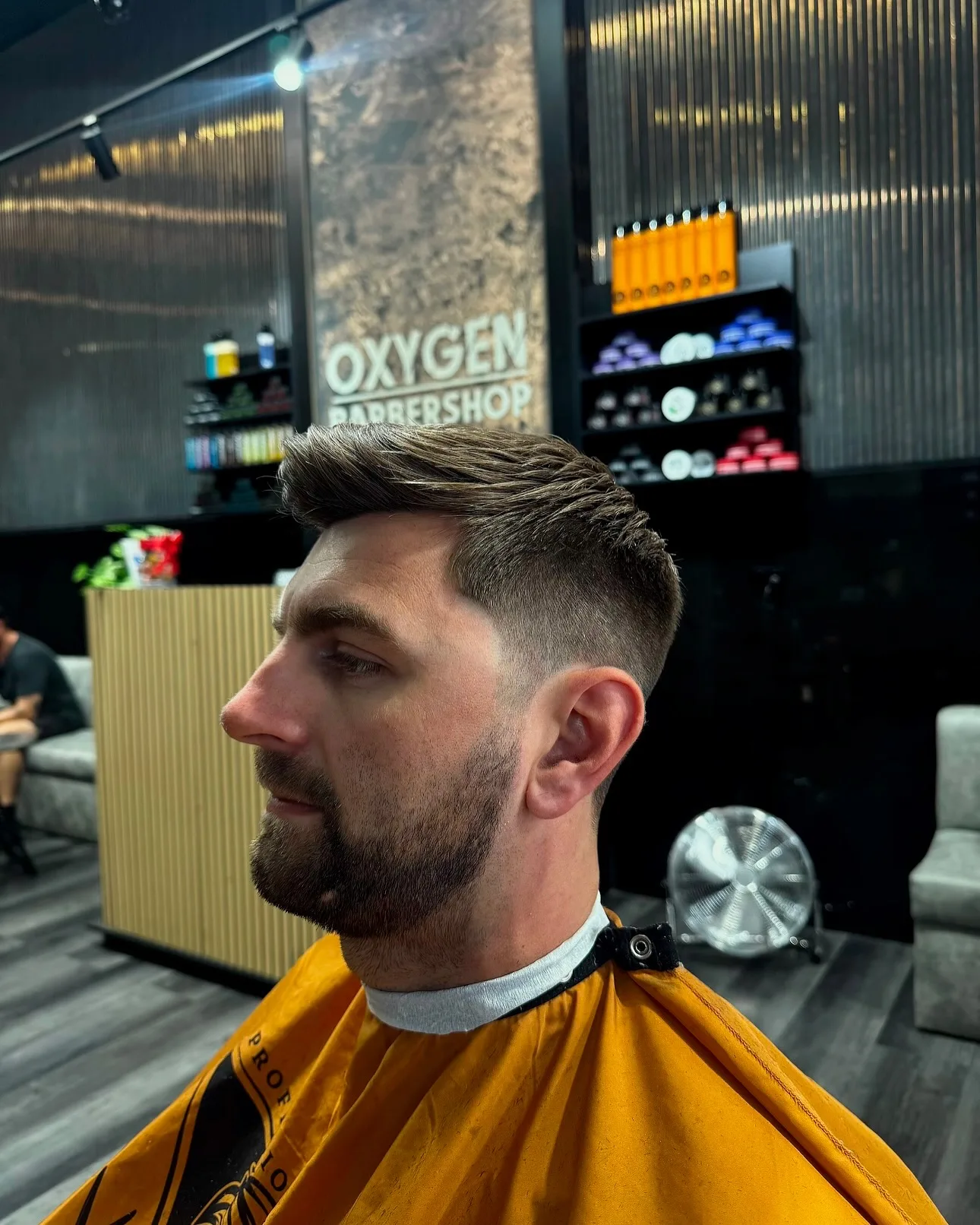 Side profile — brushed quiff, fade, and beard in the Oxygen chair